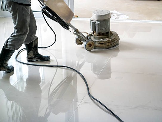 Photo of a man cleaning the floor with a cleaning machine.